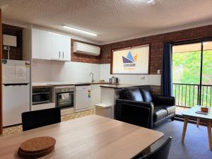 a kitchen with a table and a dining room at Leski Club in Jindabyne