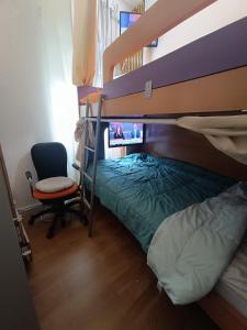 een slaapkamer met een stapelbed en een stoel bij Sams Healing Guest House in Amadora