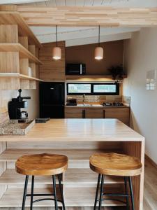 een keuken met een groot aanrecht met 2 krukken bij Casa Franca in José Ignacio