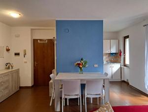 a kitchen with a table and chairs and a blue wall at Oasi Pieve in Pian di Scò