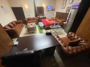 ein Wohnzimmer mit Ledersesseln und einem Tisch in der Unterkunft Secure Private Apartment Privacy Guaranteed in Lahore