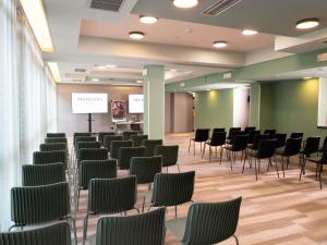 a room with rows of chairs and a podium at Mercure Bologna Centro in Bologna