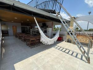 un patio con tavoli, sedie e amaca di Pousada Deck a Carolina