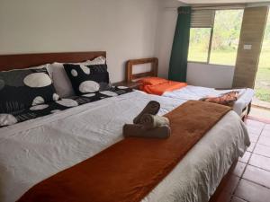 a bedroom with two beds with towels on them at Hospedaje Rural Pistacia Vera - Villa de Leyva in Villa de Leyva +10 photos