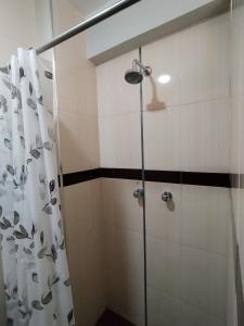 a shower with a glass door in a bathroom at La Merced in Juliaca