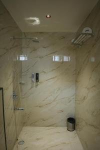 um banheiro com chuveiro e uma grande parede de mármore em Hotel Jasraj Inn em Rānchī mais 32 fotografias
