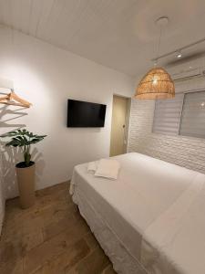 En eller flere senge i et værelse på Kanga Suítes - Aquário