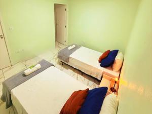 una piccola stanza con due letti e uno specchio di Golden Garden Hostel a Ubatuba