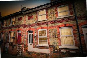 un vecchio edificio in mattoni con porte e finestre bianche di Colchester CntrCosyOfficePatioTrainParkPet a Colchester