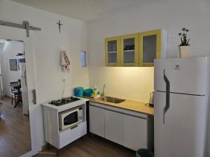 a kitchen with a white refrigerator and a sink at Flat Privativo Rua das Pedras in Búzios