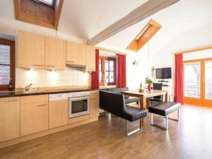 een keuken met houten kasten en een tafel en stoelen bij Zederhaus in Mariapfarr