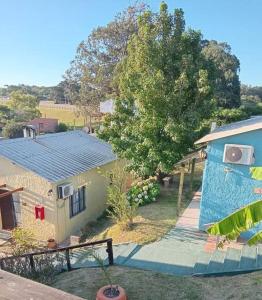 una vista aérea de una casa con un árbol en Bungalows Atardecer Apart Hotel, en Atlántida