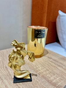 Eine goldene Frauenstatue auf einem Tisch neben einer Kerze in der Unterkunft Studio Glamour in Casablanca + 19 Fotos
