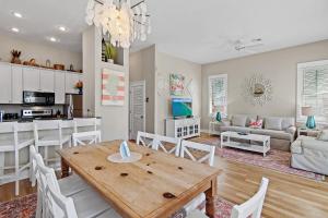 a kitchen and living room with a wooden table and chairs at Shore Fun At Destin Pointe Resort in Destin