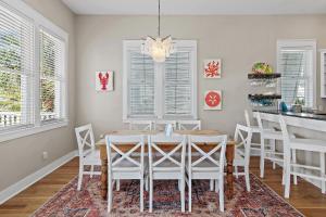 a dining room with a white table and chairs at Shore Fun At Destin Pointe Resort in Destin