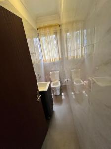 um banheiro com dois vasos sanitários e uma pia em She properties em Dawhwenya
