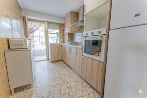 eine Küche mit Holzschränken und einem weißen Kühlschrank in der Unterkunft Front Sea Santa Pola in Santa Pola