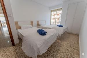 drei Betten in einem Zimmer mit Fenster in der Unterkunft Front Sea Santa Pola in Santa Pola