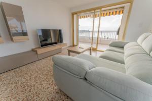 ein Wohnzimmer mit Sofa und Fernseher in der Unterkunft Front Sea Santa Pola in Santa Pola