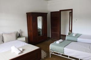 una camera da letto con due letti e uno specchio di Catalina House ad Alta Gracia