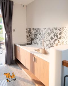 a kitchen with a sink and a tile wall at Thỏ Chill Homestay in Vung Tau +92 photos