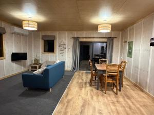 a living room with a blue couch and a table at Kotare View- Studio accommodation, Tataraimaka in Tataraimaka