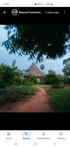 una pagina di un sito web con una strada sterrata con un edificio di Beyond Guest House ad Auroville