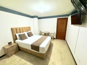 a bedroom with a bed and a table in it at Hotel Pereira Central in Pereira