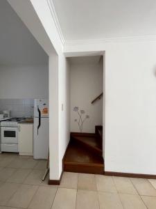 a kitchen with white walls and a white refrigerator at Casa Storni in Mar del Plata