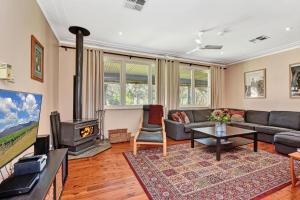 a living room with a couch and a fireplace at Glandore Estate in Pokolbin