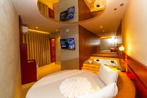 a bedroom with a large bed and a bath tub at Sensações Suítes - Adults Only in Arraial d'Ajuda