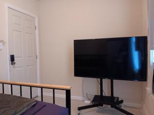 een flatscreen-tv op een stand in een slaapkamer bij Hostel Tampa, near downtown, Ybor City, 15 minutes drive to airport in Tampa