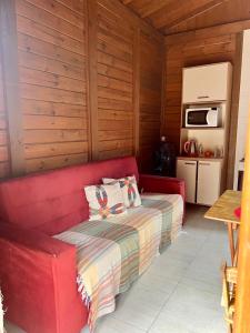 un divano rosso in una stanza con cucina di Rose-mar a Imbituba