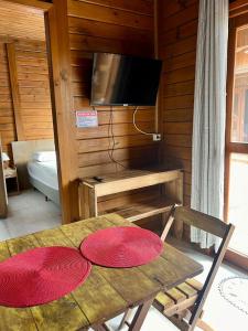 un tavolo con due piatti rossi sopra e una televisione di Rose-mar a Imbituba