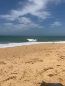 una spiaggia sabbiosa con l'oceano sullo sfondo di Rose-mar a Imbituba