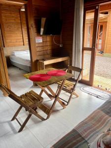 una stanza con un tavolo, una sedia e una televisione di Rose-mar a Imbituba