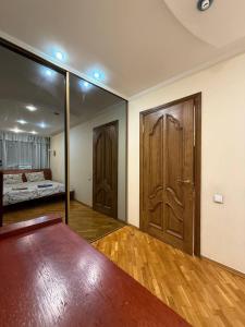 Zimmer mit zwei Holztüren und einem Bett in der Unterkunft Воскресенская 12- 2 кв Евро Центр in Dnipro