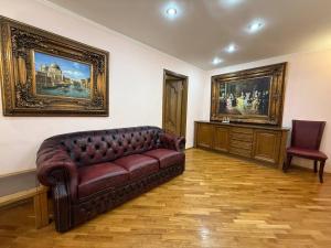 ein Wohnzimmer mit einem Sofa und Gemälden an der Wand in der Unterkunft Воскресенская 12- 2 кв Евро Центр in Dnipro