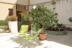 a green chair and a tree in a courtyard at Apartment Casa Francesca in Syracuse