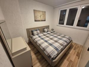 a small bedroom with a bed and a window at Nice apartment at the center of Vushtrri city in Mitrovicë