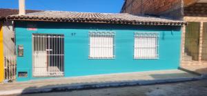 een blauw gebouw met geblokkeerde ramen in een straat bij Casa Abade - 4 Quartos - Excelente Localização in Itacaré