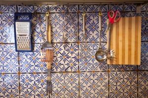 恩納的住宿－La Casa Sulla roccia，墙壁上用蓝色和白色瓷砖装饰,配有餐具