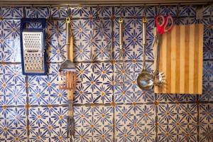 a wall with blue and white tiles with utensils at La Casa Sulla roccia in Enna +44 photos