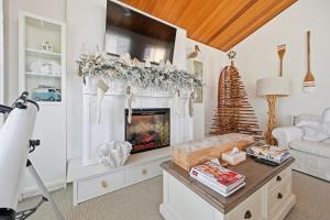 a living room with a fireplace and a christmas tree at The Inverloch Beach House in Inverloch