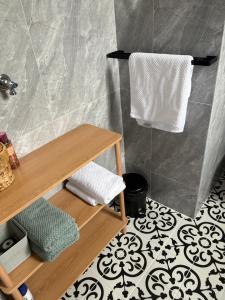 une salle de bains avec une étagère en bois et des serviettes blanches dans l'établissement Monee apartment, à Melbourne