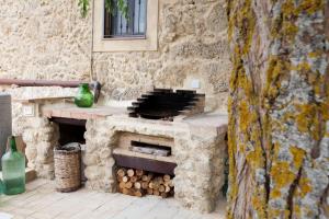 a stone oven with a pile of fire wood at La Casa Sulla roccia in Enna