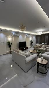 un ampio soggiorno con divani e televisione di جوهرة العزيزية a Dhahran