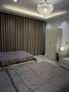 una camera da letto con un letto e un lampadario di جوهرة العزيزية a Dhahran Altre 7 foto