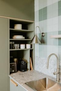 a kitchen with a sink and a shelf with dishes at Hahndorf Farm Barn in Hahndorf +146 photos