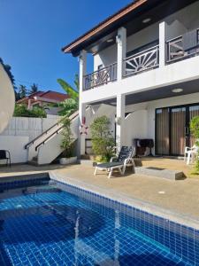 a villa with a swimming pool in front of a house at BEA Privileged Apartment in Lamai